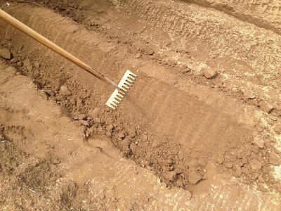 Farm beds using rake to pack and level bed sides again