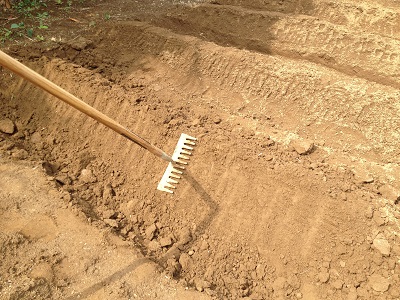 Farm beds using rake to pack and level bed sides